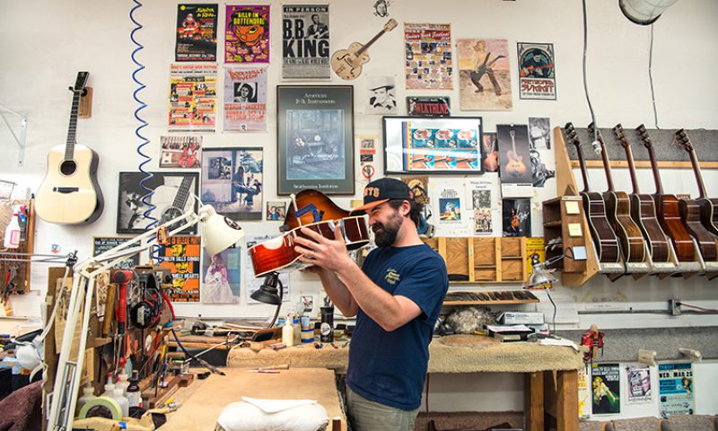 man checking a guitar