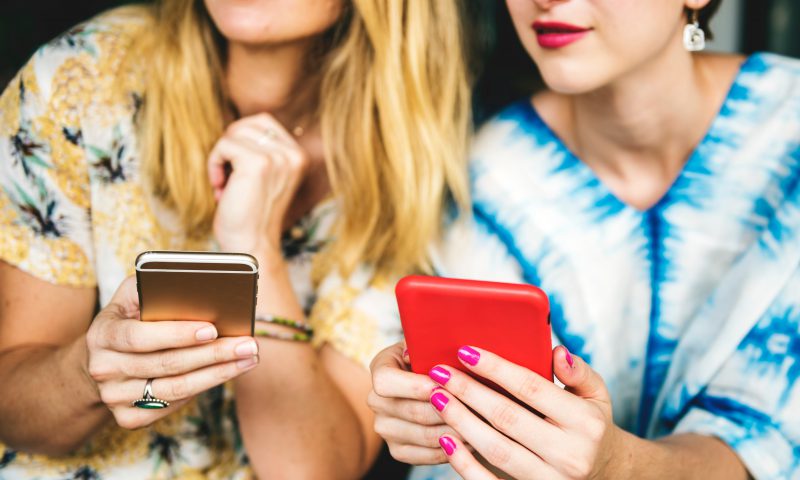 Two women holding their phones